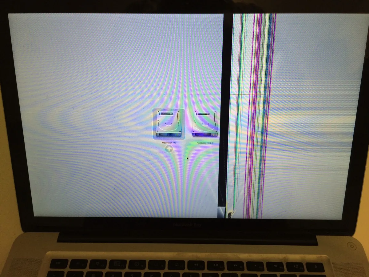 Schermo di un MacBook con linee verticali colorate concentrate su una sola zona del display